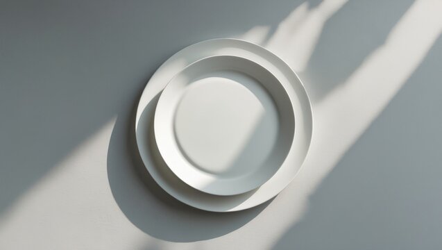 Flatlay of an empty white plate on a light stone background with blank space for text, top view