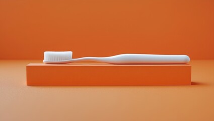 Close-up of a white toothbrush with textured bristles and handle against an orange background for product display
