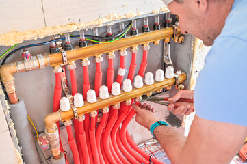 The image showcases a modern plumbing installation featuring red piping, valves, and fittings, illustrating the intricacies of plumbing work and craftsmanship