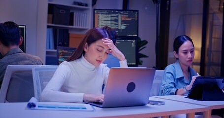 Diverse AI engineers working late in high-tech office, coding algorithms, analyzing data, and building intelligent systems. Focused teamwork and innovation drive future-ready software development.