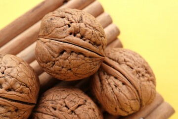 Orzechy włoskie na drewnianych patyczkach i żółtym tle