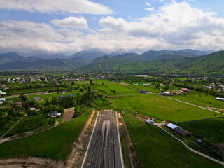 Villages on the outskirts of the city, in a mountainous area. Drone view, spring time, partly cloudy