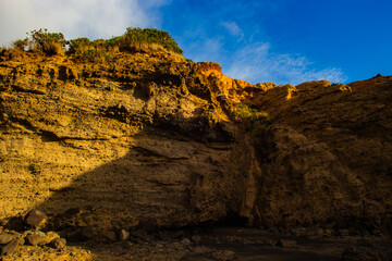 Obraz premium Layers of rocks and stones in the Piha beach cliff walls in Auckland, New Zealand.