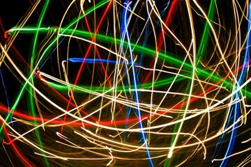 Abstract colorful light trails on black