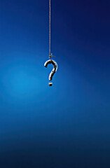 A solitary question mark dangles against a deep blue background, symbolizing the complexity of inquiries and the pursuit of knowledge in an ever-changing world.