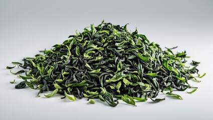 Pile of dried green tea leaves on a white background