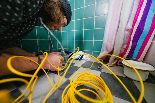 Man examining bathroom drainage at home