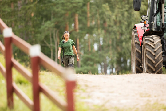 Female farmer walking on agricultural field at sunny day