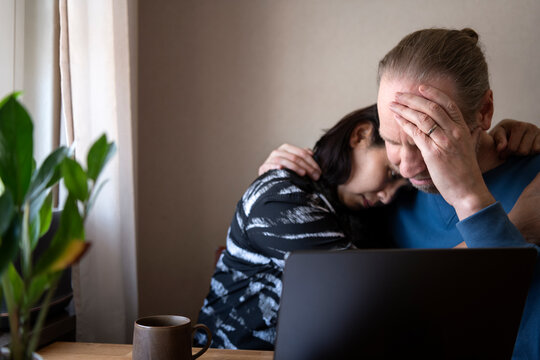 Caring woman embracing stressed man at home
