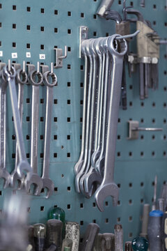 Open ended wrenches hanging on hook in cabinet