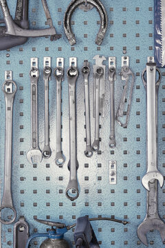 Different sizes of wrenches hanging in cabinet