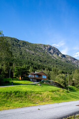 A rural landscape in the Sunnfjord district of Western Norway, located in the Sogn og Fjordane county, with a farmhouse with large mountains behind it and unspoiled nature without people