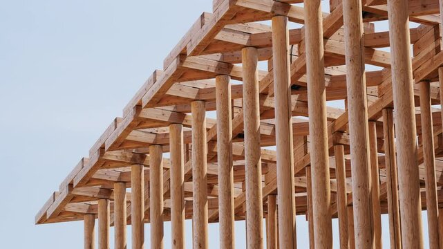 Architectural detail of an intricate timber framework against clear sky.