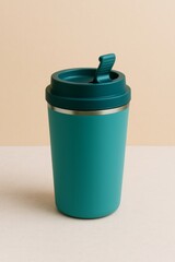 Obraz premium A modern teal travel mug on a beige surface, Perfect for enjoying your favorite drinks on the go