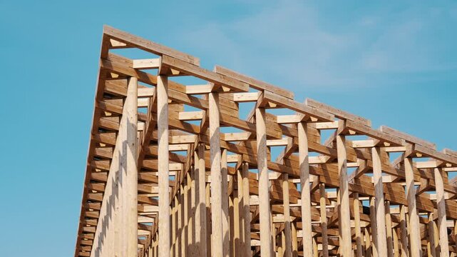 Architectural detail of an intricate timber framework against clear sky.
