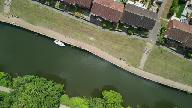 Drone pans over parklined canal with paths, benches and bridges in Maidstone, Kent
