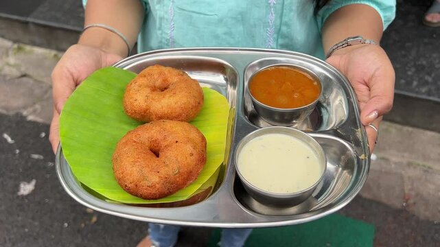 Masala Vada, a popular street food of South Indian cuisine served with chutney and sambhar.
