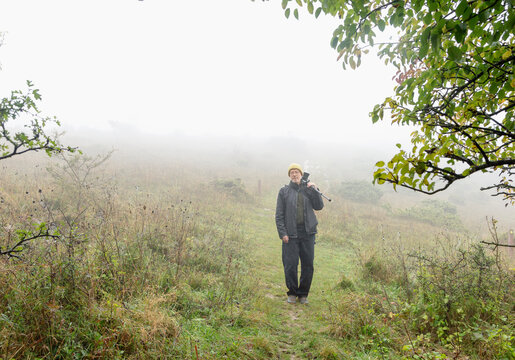 Portrait of mature man walking with insect repellent on farm