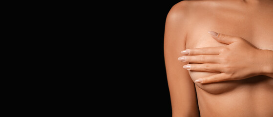 Naked young woman with beautiful breasts on black background, closeup