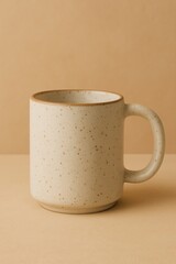 A beige speckled mug, perfect for enjoying your favorite beverage, sits gracefully