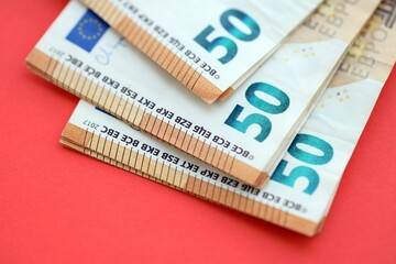 Big amount of european euro currency money notes on red color table close up