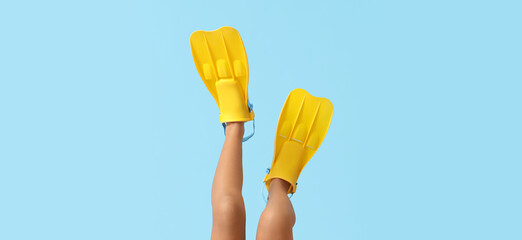 Girl legs in flippers on blue background, closeup © Pixel-Shot