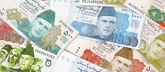 Pakistan rupees banknotes. The current Pakistan money bills lies on table in big amount