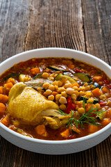 Fresh vegetable soup with lentil, chickpea and chicken on wooden table	