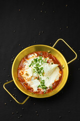 Poached egg in tomato sauce with herbs.