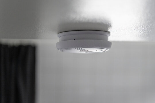 Close-up of smoke detector mounted on ceiling