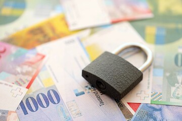 Swiss franc banknotes and padlock. The current francs money bills with lock lies in big amount