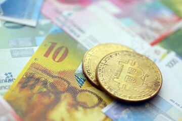 Swiss franc banknotes and bitcoin. The current francs money bills and bit coin lies on table