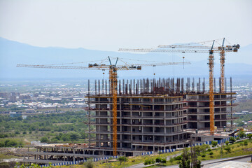 Construction of multi-storey buildings. Crane and skyscraper. Builders build houses