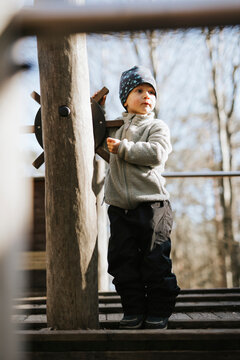 Cute boy playing with helm in jungle gym