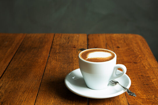 Cup of coffee with spoon kept on wooden table