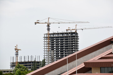 Construction of multi-storey buildings. Crane and skyscraper. Builders build houses