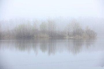Foggy day. Island on the lake in foggy weather