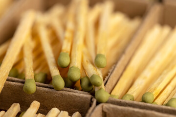 wooden matches with head in cardboard boxes , the green head of a wooden match laid out in cardboard boxes, close up