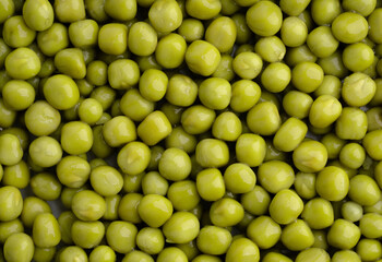 Fresh green peas background, texture of perfect peeled sweet pea grains as background. Vegetable background, vegetable protein, healthy products. Canned peas.