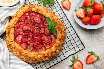 Delicious homemade strawberry galette decorated with almond petals and fresh mint