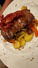 A juicy steak of meat is served alongside golden, crispy potatoes, creating a classic and hearty meal. The rich flavors and satisfying textures make it a favorite comfort dish in many cuisines.