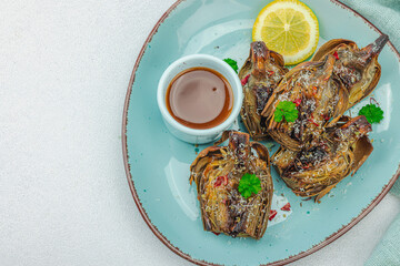 Delicious baked artichoke with parmesan cheese and sauce. Olive oil, garlic, parsley and lemon
