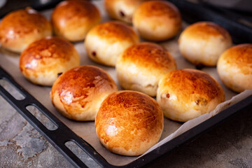 Homemade buns with raisins on a baking sheet. Delicious breakfast: sweet rolls. Close-up