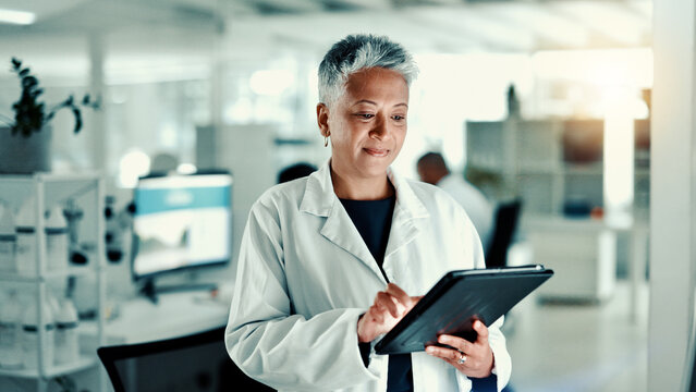 Mature woman, scientist and tablet in lab for medical research, gene function and experiment. Person, digital and gmo editing for cell study, review report and virus information for vaccine results