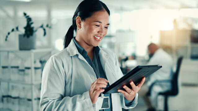 Scientist, woman and typing with tablet at lab for progress report, review and happy for medical research. Person, smile and digital touchscreen with application for results for pharmaceutical study