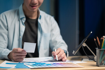 Male coder or developer working overtime using a computer display in problem solving at workplace.