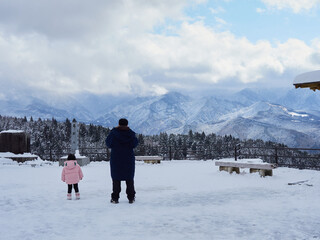 観光名所中山道の馬籠宿の展望台から見た恵那山の雪景色と観光客の姿