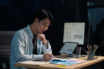 Male coder or developer working overtime using a computer display in problem solving at workplace.