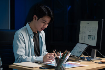 Male coder or developer working overtime using a computer display in problem solving at workplace.