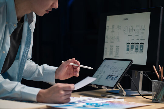 Male coder or developer working overtime using a computer display in problem solving at workplace.